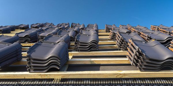 Roof ceramic tile arranged in packets on the roof on roof battens. Preparation for laying roof tiles.