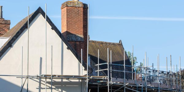 Scaffold pole platform erected for roof construction and repair work on rural building England, UK.